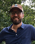 photo of Richard Callahan wearing a baseball cap, blue polo, with trees in the background.