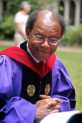 James Cone outside in graduation regalia