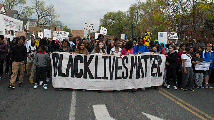 Students march in protest with a large banner sign, "Black Lives Matter"