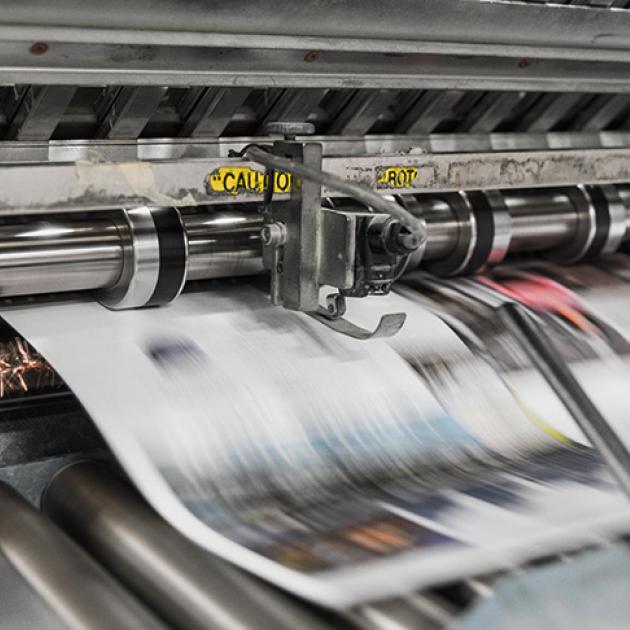 Two newspaper are being printed on a modern press