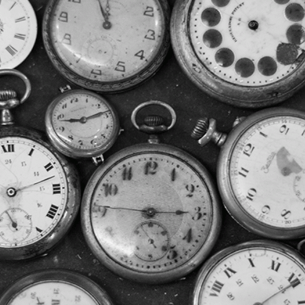 black and white photo of several pocket watches
