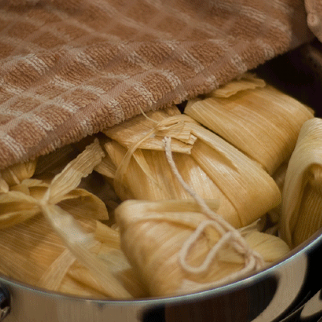 A pot filled with roasted corn tamales